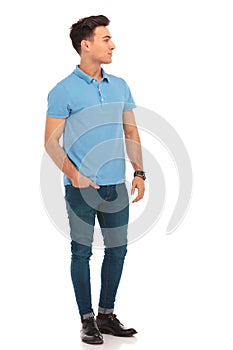 Man in blue shirt posing with one hand in pocket