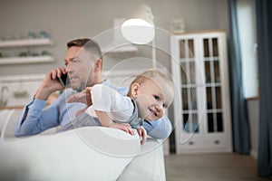 Man in a blue shirt speaking on the phone and looking serious