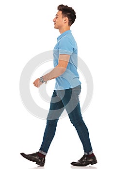 Man in blue shirt walking in isolated studio background