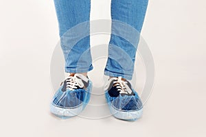 Man with blue shoe covers worn over sneakers