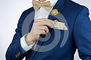 Man blue suit bowtie, brooch, pocket square