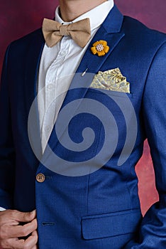 Man in blue suit bowtie, pocket square