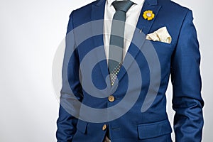 Man blue suit necktie, brooch, pocket square