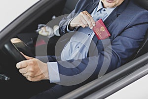 Man in blue suit shows red ID card or pass. An important untouchable employee of ministry is driving a car. state Duma