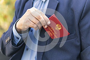 Man in blue suit shows red ID card or pass. An important untouchable employee of ministry is driving a car. state Duma