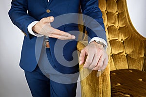 Man in blue suit standing beside sofa