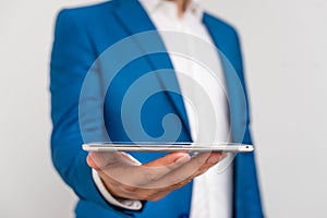 Man in the blue suite and white shirt holds mobile phone in the hand. Business concept with businessman and mobile phone