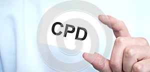 Man in blue sweatshirt holding a card with text CPD,business concept photo