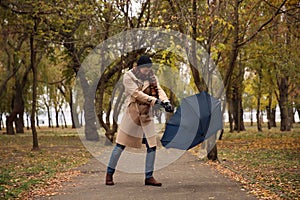 Man with blue umbrella caught in gust of wind outdoors