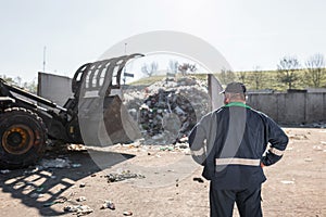 Man looking at garbage at landfill