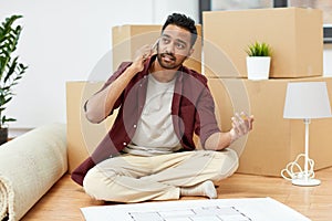 Man with blueprint and boxes moving to new home