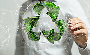 A man on blurred background using volumetric green recycling sign 3d  digital