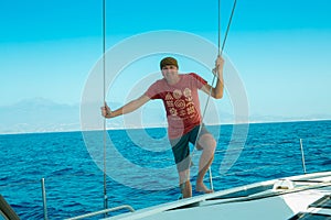 A man on board a sailing yacht at sea. Yachting.