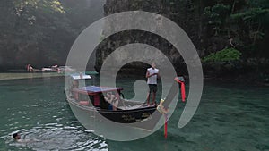 Man on boat controls drone. Guy man tourist traveler vacationer standing on boat gondola in middle of sea water