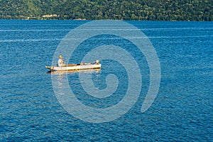 Man in boat relaxing and fishing on Danube river on a sunny day in Orsova, Romania, 2020