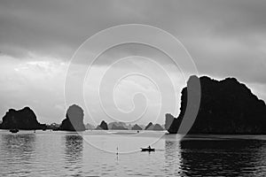 Man is boating in the sea near rocks in water