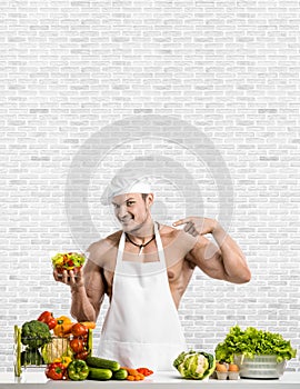 Man bodybuilder in white toque blanche and cook protective apron