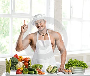 Man bodybuilder in white toque blanche and cook protective apron