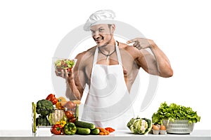 Man bodybuilder in white toque blanche and cook protective apron