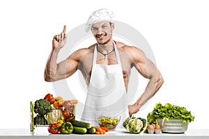 Man bodybuilder in white toque blanche and cook protective apron