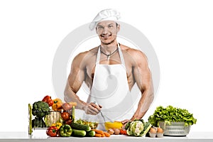 Man bodybuilder in white toque blanche and cook protective apron