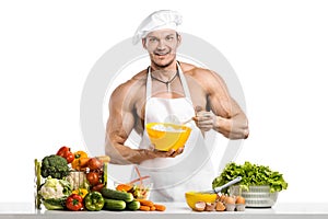 Man bodybuilder in white toque blanche and cook protective apron