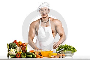 Man bodybuilder in white toque blanche and cook protective apron