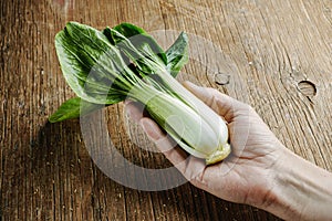 man with a bok choy in his hand photo