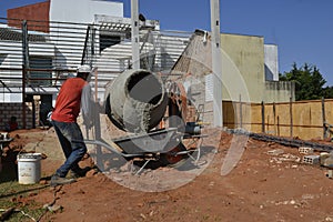 Man, construction worker using cement mixer, Brazil, south America