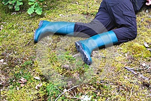 A man in boots lies in the forest on the grass. The concept of a lost person, dehydration. Copy space for text. Accident