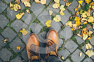 Man boots top view with yellow leaves