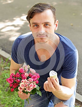 Man with a bouquet of roses and a diamond ring
