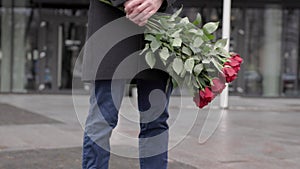 man with bouquet roses standing street waiting meeting. Close-up Valentine's Day