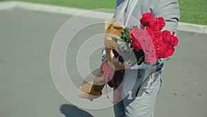 Man with a bouquet of roses waits for a girl, romantic or first date, proposal to marriage