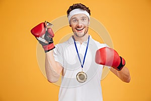 Man boxer in red gloves and medal holding trophy cup