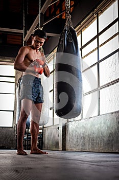 Man boxer wrapping his hand in boxing arena sport.