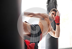 Man, boxing and bag kick for workout class or cardio challenge or fitness practice, training or combat. Athlete
