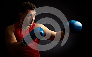 Man boxing on black background