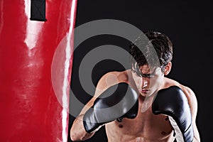 Man, boxing gloves and bag for fitness practice or cardio exercise for health, fighter or black background. Male person