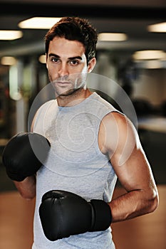 Man, boxing gloves and exercise with gym portrait for health, wellness or training for fight, performance or sport. MMA