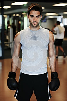 Man, boxing gloves and fitness with gym portrait for health, wellness or training for fight, performance or sport. MMA