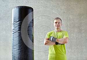 Man with boxing gloves and punching bag in gym