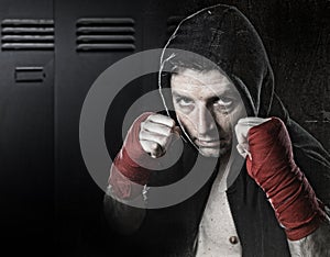 Man in boxing hoodie jumper with hood on head wearing hand and wrist wrapped ready for fighting