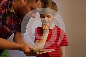 Man and boy hold money in their hands