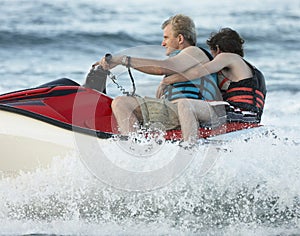 Man and Boy jetskiing in sea photo