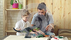 Man and boy play together on wooden wall background. Family and childhood concept. Father and son play with toys