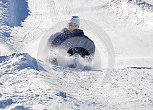 Man Braking While Sledding Down the Hill