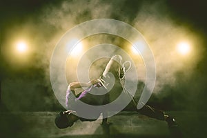 Man break dancing with smoke and light background