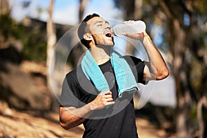 Man, break and drinking water with towel in outside for relief with fitness, thirsty and exhausted in nature for