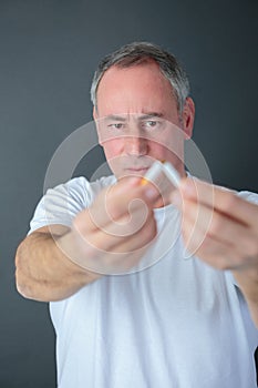 Man breaking cigarette as gesture quitting smoking